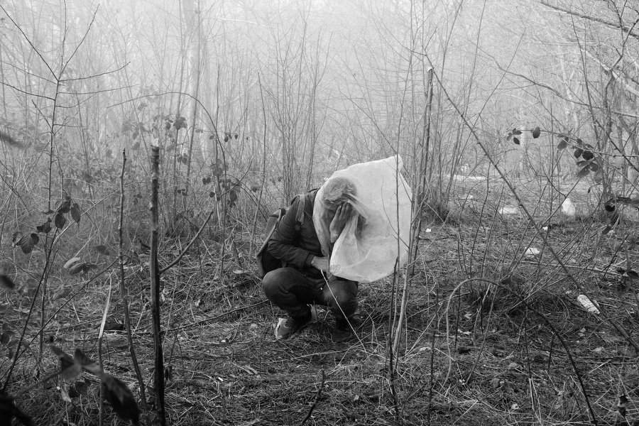 TURKEY. Edirne. 2020. A man is desperately trying to protect himself from tear gas. Greek police fired it to repel hundreds of migrants who sought to force their way across the border from Turkey.