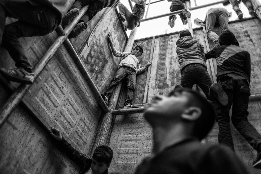Children climb a platform adorned with flags during Newroz celebrations in Diyarbakir, Turkey. In southeastern Turkey, clashes between Turkish military security forces and the Kurdish separatists resumed in the summer of 2015 after a two-year cease fire. Diyarbakir, Turkey, March 2016.